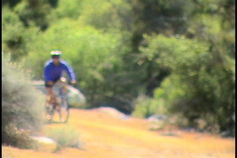 Steadicam Shot Of Two Healthy Men Peddling Fast With Cycling Road Bicycle At Sunset Stock