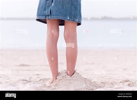 Mädchen Stehen Am Strand Mit Füßen In Sand Niedrige Abschnitt Begraben Stockfotografie Alamy