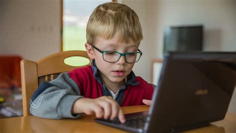 Enthusiastic Kid On Laptop Computer Sliding Over Computer Screen With