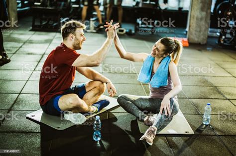 Happy Athletic Couple Giving Each Other Highfive On Water Break In A
