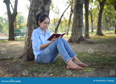 Asian Woman Reading The Book Under Tree In The Garden Stock Image