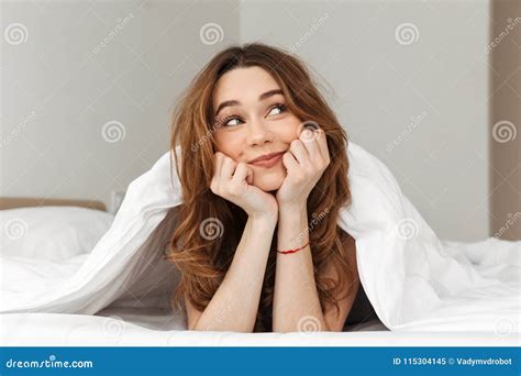 Portrait Of Alluring Young Woman Lying In Bed Under Blanket At H Stock