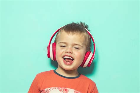 Niño Que Escucha La Música Con Los Auriculares Foto De Archivo Imagen