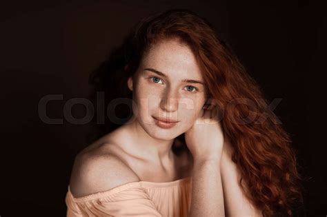 Beautiful Tender Redhead Woman With Perfect Skin Posing In Beige Blouse Isolated On Brown