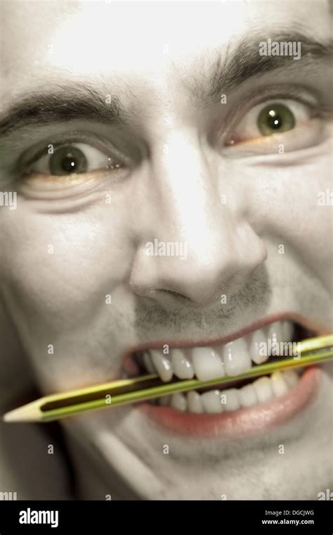 Man Biting A Pencil Stock Photo Alamy