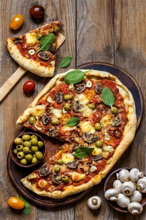 Pizza With Mushrooms Olives Spinach And Sausage On A Dark Background