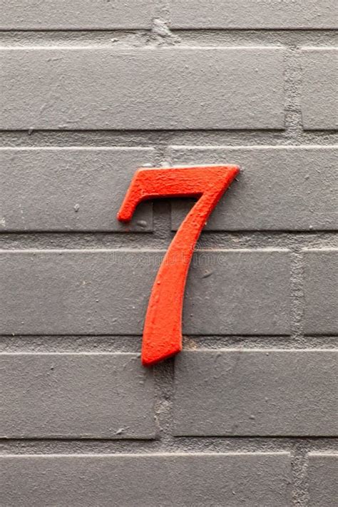Number 7 Orange Vintage House Number On Gray Brick Tile Wall Stock