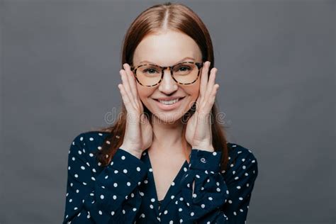 Photo Of Attractive Woman With Pleased Facial Expression Keeps Both