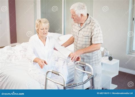 Hogere Man Die Zieke Vrouw Helpen Bij Het Opstaan Van Bed Stock