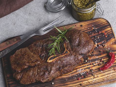 Juicy Grilled Beef Steak With Bone On A Cutting Board Spices Sauce Pesto Stock Image Image