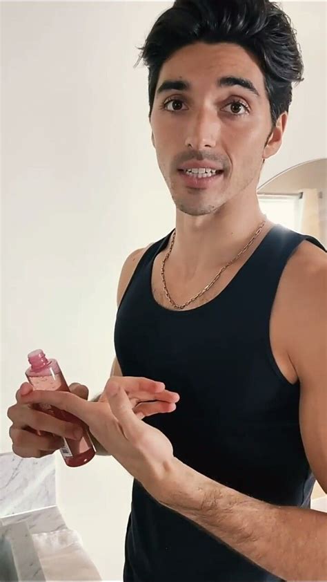 A Man Holding A Toothbrush In His Right Hand And Looking At The Camera