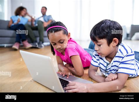 Brother And Sister Lying On Floor And Using Laptop Stock Photo Alamy