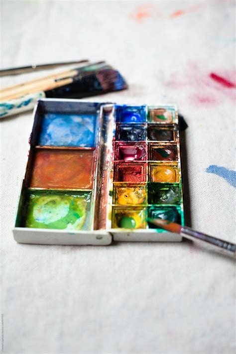 Mini Palette Of Well Loved Paints On A Canvas With Brushes By Stocksy Contributor Carolyn