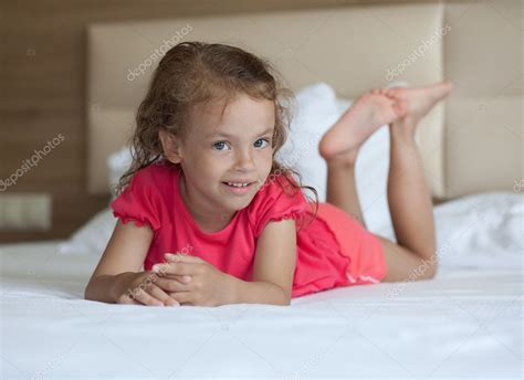 Cheerful Little Girl Lying On The Bed — Stock Photo © Yykkaa 6893947