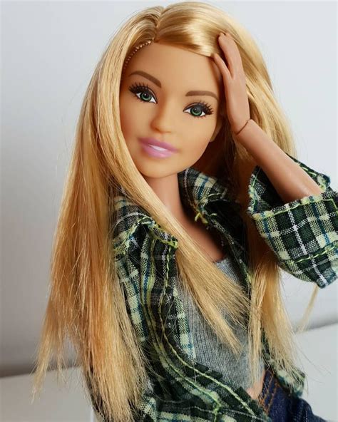 A Blonde Doll With Long Hair Sitting On A Table