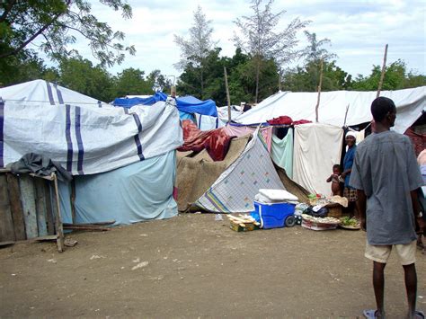 Free Picture Haitian Man Standing Outside Makeshift Tent Homes