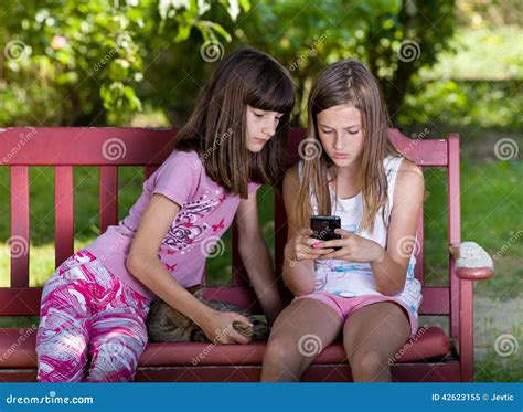 Flickor med mobiltelefonen fotografering för bildbyråer Bild av barn