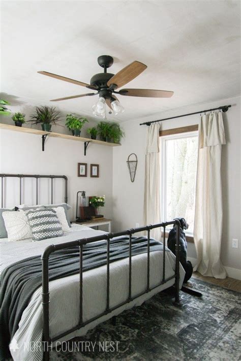 A Bed Room With A Neatly Made Bed And A Ceiling Fan