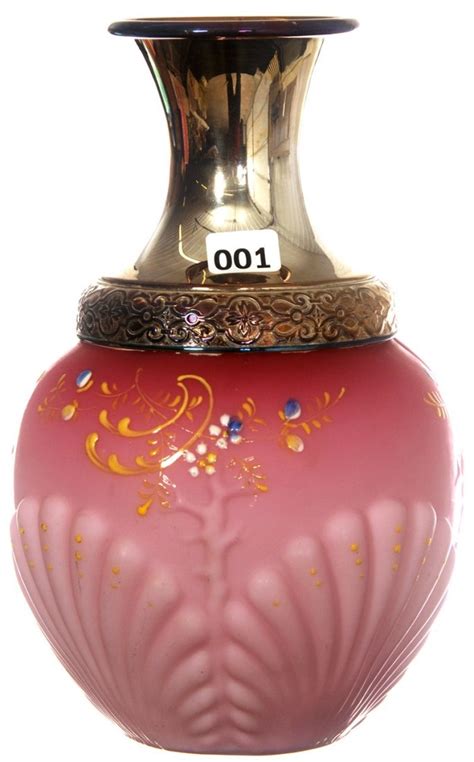 A Pink Vase With Gold Decoration On The Top