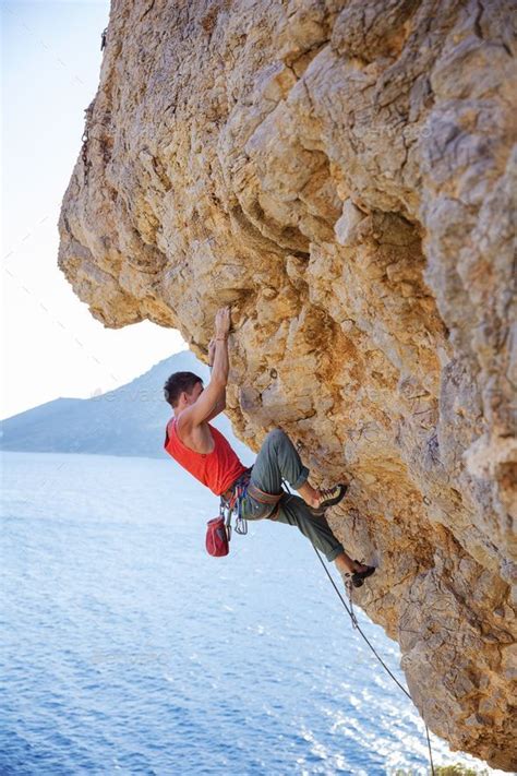 Young Man Lead Climbing On Overhanging Cliff Rock Climbing