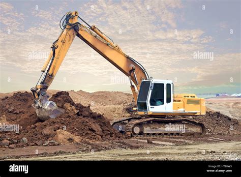 Excavator digging and moving earth at construction site Stock Photo - Alamy