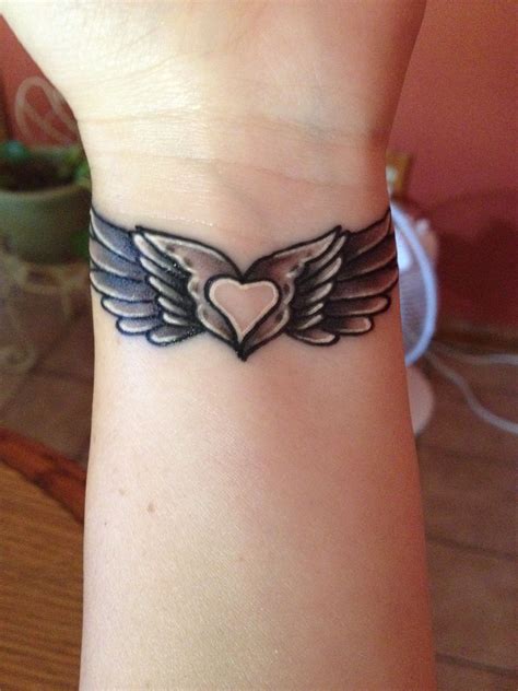 my angel wing tattoo with a heart in the middle wing tattoos on wrist wrist tattoos for women