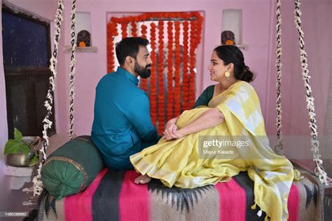 mature indian couple sitting on a swing and spending a good time with each other high res stock
