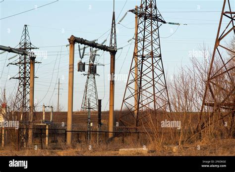 A High Voltage Power Line Next To An Electrical Substation Stock Photo