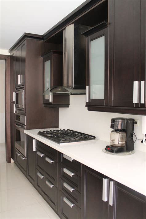 A Kitchen With Brown Cabinets And White Counter Tops Including A