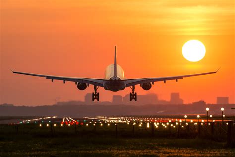 Passenger plane is landing during a wonderful sunrise. - Digital