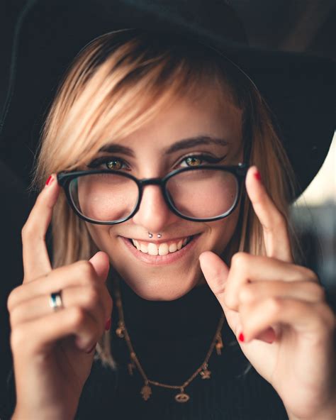 A Woman Wearing Black Framed Eyeglasses And A Hat Pixeor Large