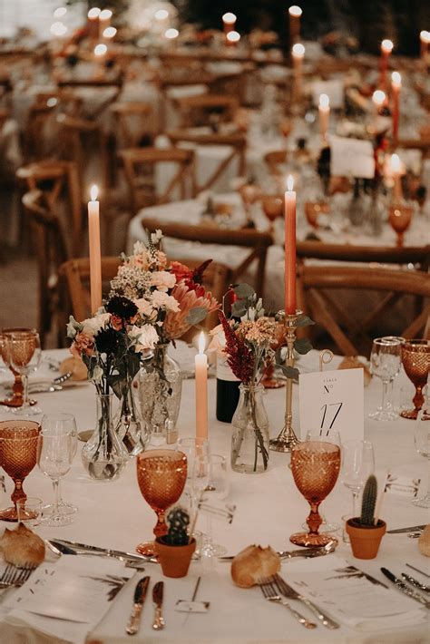 The Table Is Set With Candles And Flowers