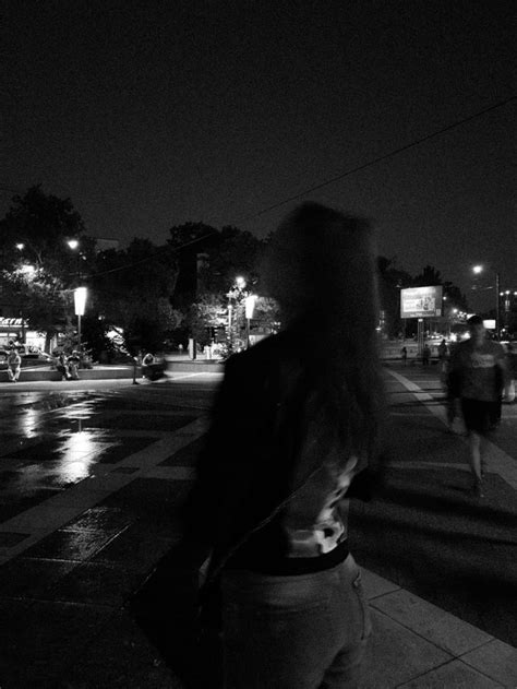 a woman walking down the street at night