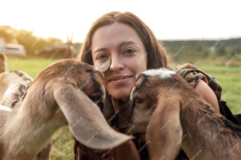 Premium Photo Beautiful Woman Farmer With Small Goat In Countryside Have Friendship In Nature