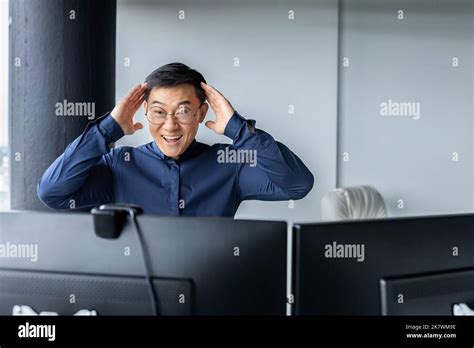 Happy Business Broker Looking At Two Paired Computer Monitors And Happy