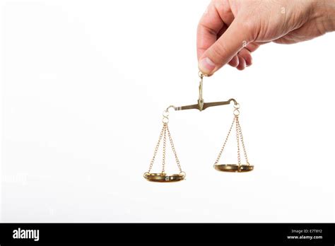 Hand Holding Golden Scales Of Justice Isolated On White Background