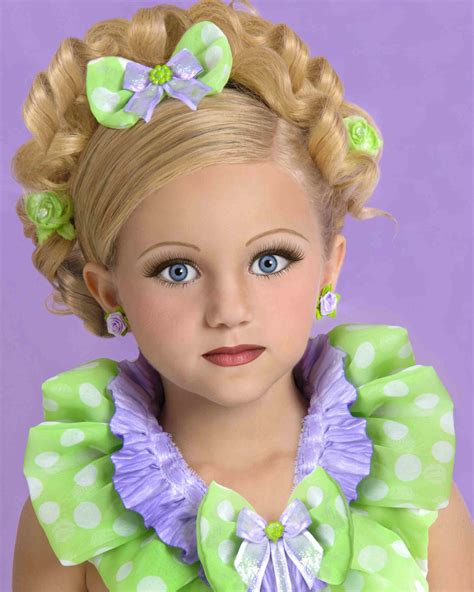 A Doll With Blonde Hair And Blue Eyes Is Wearing Green Polka Doted Dress Purple Bow
