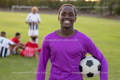 Portrait Of Happy African American Goalkeeper With Soccer Ball Standing