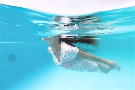 Beautiful Woman Dressed In White Shirt Swimming Trough The Pool In Summertime By Jovana Milanko
