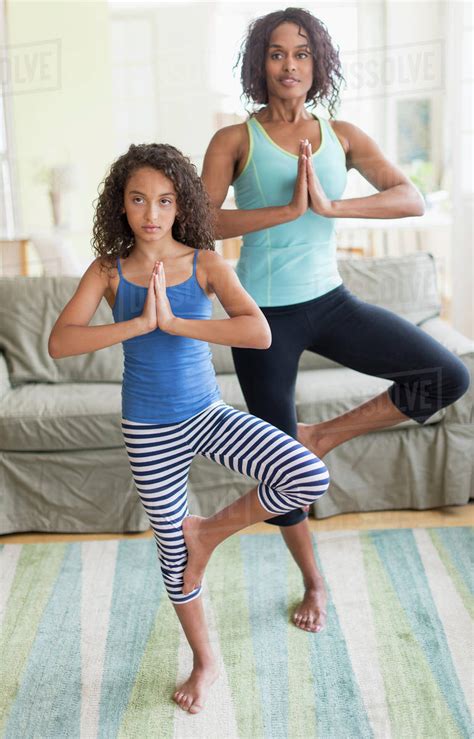 Mother And Daughter 8 9 Doing In Yoga Poses In Living Room Stock