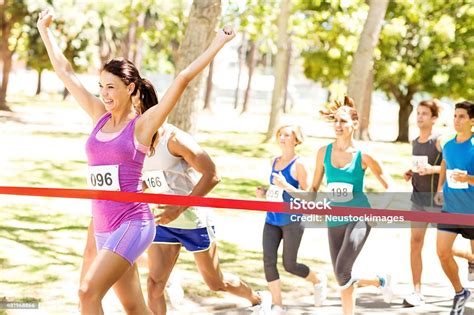 Female Marathon Runner Crossing Finish Line Stock Photo Download