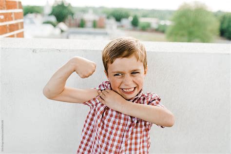 Young Boy Flexing Muscles By Stocksy Contributor Erin Drago Stocksy