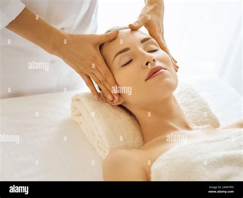 Beautiful Woman Enjoying Facial Massage With Closed Eyes In Spa Center Relaxing Treatment