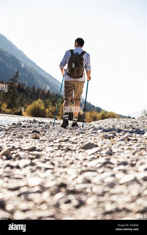 Austria Alps Man On A Hiking Trip Walking On Pebbles Along A Brook