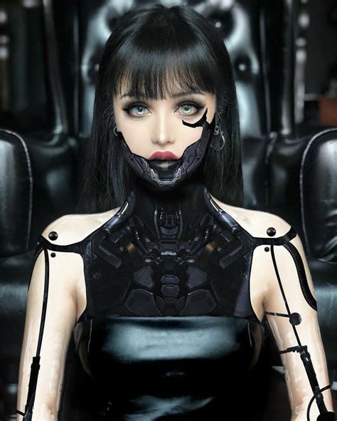 A Woman With Black Hair And Piercings On Her Face Is Sitting In A Chair