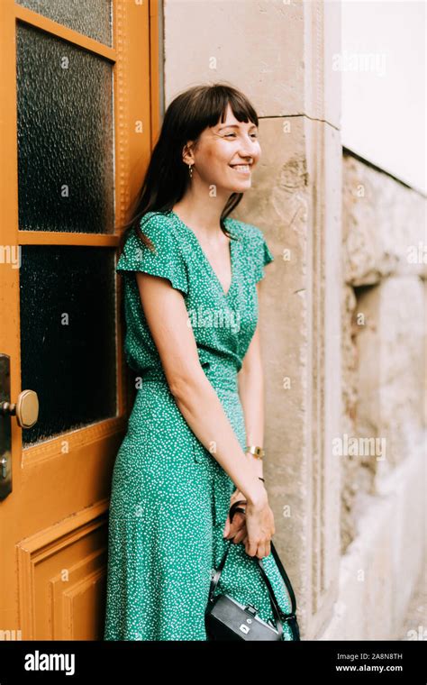 Elegant Woman Wearing A Green Dress Is Laughing With An Old Film Camera In Her Hands Stock Photo