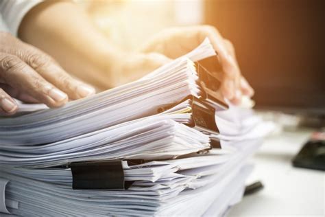 Businessman Hands Searching Information In Stack Of Papers Files On