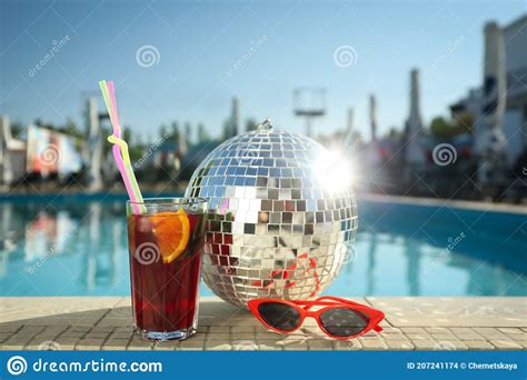 Shiny Disco Ball Refreshing Cocktail And Sunglasses On Edge Of Swimming Pool Party Items Stock