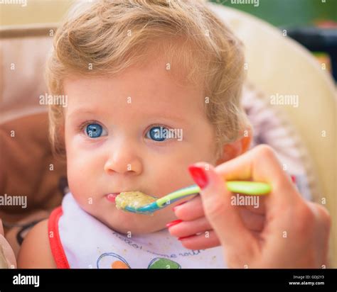 A Mother Feeding Her Baby Boy With Spoon Outdoor Stock Photo Alamy