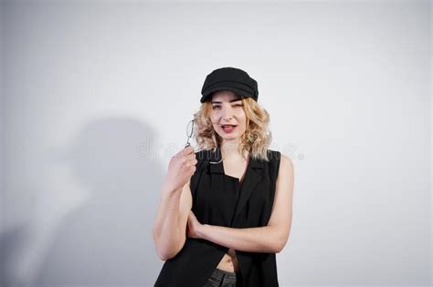 Studio Portrait Of Blonde Girl In Black Wear And Cap Stock Photo